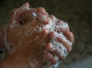 Handwashing before and after contact with individuals with contagious infections is key. See this article to determine additional recommendations for protective gear such as gloves and gown as well use of hand sanitizer. 